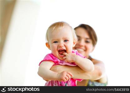 Laughing baby playing with mother