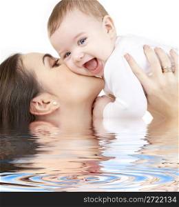 laughing baby playing with mother in water