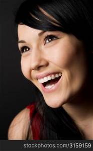 Laughing black haired woman in red top