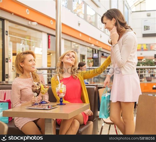 Laughing female friends in the small shopping mall cafe