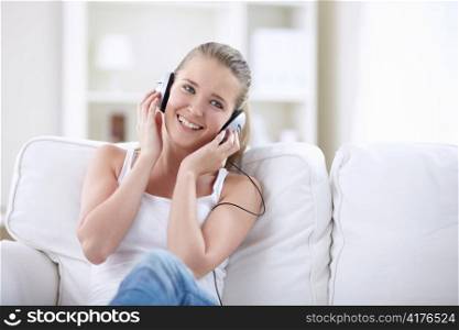 Laughing girl listens to music on headphones