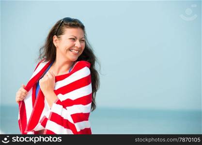 laughing girl with red striped towel on the beach