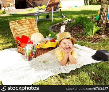 laughing kid resting next to the wicker basket