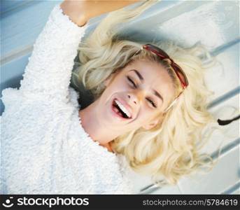 Laughing lady lying on the wooden floor