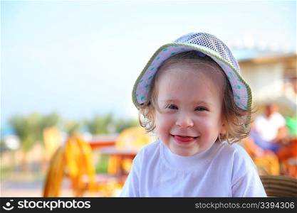 laughing little girl in hat outdoor portrait