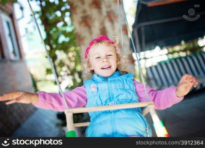 Laughing little girl on swing