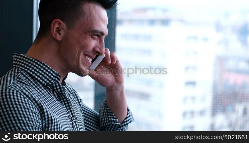 laughing man talking on the phone in office interior