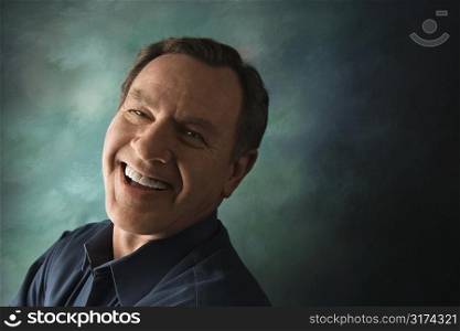 Laughing middle-aged Caucasian man on studio background.