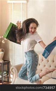 laughing pretty young woman holding shopping bags and jumping. pretty young woman jumping