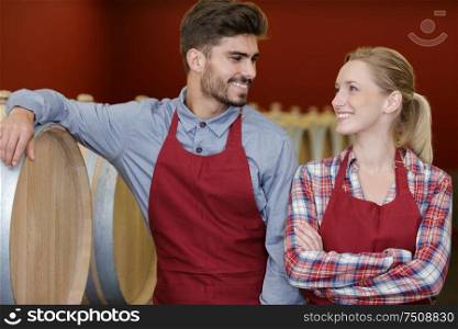 laughing professional team of winery in wine cellar