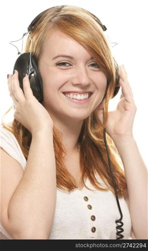 laughing redhead girl with headphones listening to music. laughing redhead girl with headphones listening to music on white background