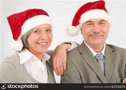 Laughing senior businesspeople having fun with Xmas Santa hat