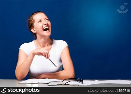 laughing woman is sitting at table and looking sideways