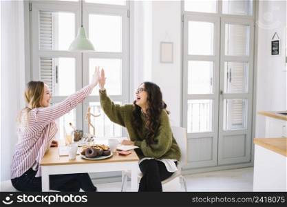 laughing women high fiving table