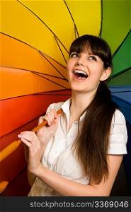 laughing young brunette woman in white blouse with multi-coloured umbrella