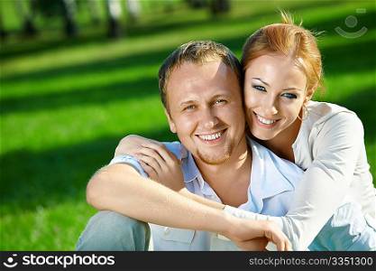 Laughing young couple embraces in a summer garden