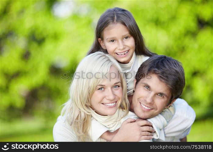 Laughing young parents with a daughter outdoors