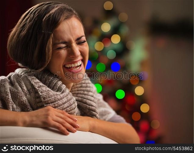 Laughing young woman in front of Christmas tree