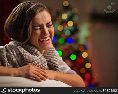 Laughing young woman in front of Christmas tree