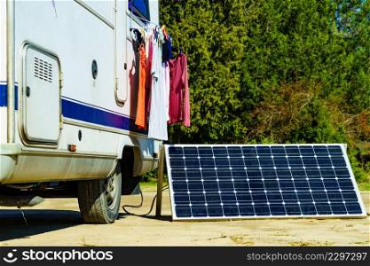 Laundry and portable solar photovoltaic panel, charging battery at camper car rv. Camping on nature.. Laundry and solar panel at caravan