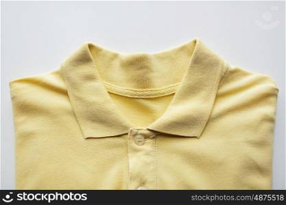 laundry, clothes, fashion and objects concept - close up of polo t-shirt on white background
