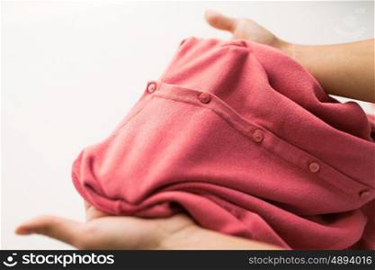 laundry, clothes, fashion and people concept - close up of hands with clothing item or cardigan