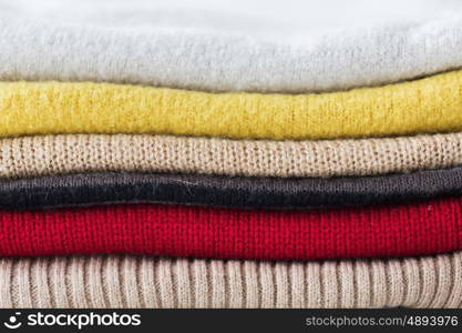 laundry, clothing, household and objects concept - close up of stacked knitted clothes