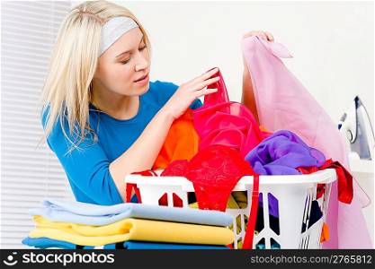 Laundry - woman folding clothes home, housework