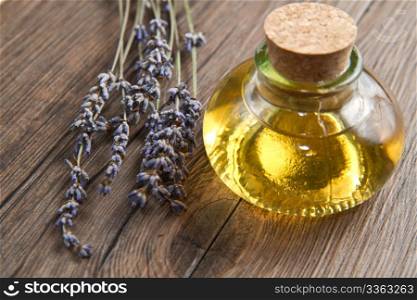 lavander oil with flowers on wooden table