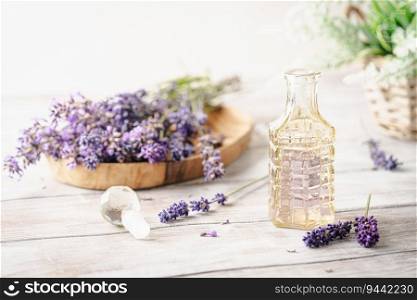 Lavender aroma liquid or flavoring. Cosmetics products in bottles with fresh lavender flowers on white wooden rustic board.. Lavender beauty products