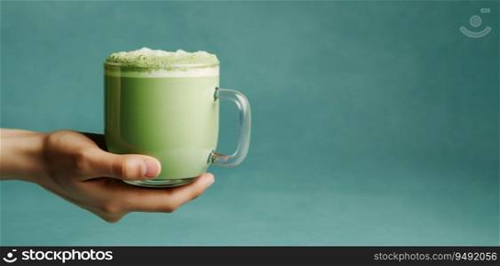 Lavender blue matcha latte in glass cup in hand on blue background