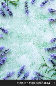 Lavender flowers and leaves creative frame on a green wooden background. Top view, flat lay. Floral composition
