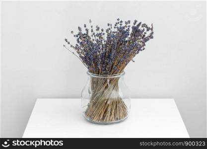 Lavender flowers in glass vase, white wooden background, spa concept, aromatherapy, copy space. Lavender flowers in glass vase, white wooden background, spa concept, aromatherapy. Lavender flowers in close up