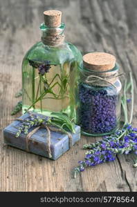 lavender oil, herbal soap and bath salt with fresh flowers on wooden background. vintage style toned picture