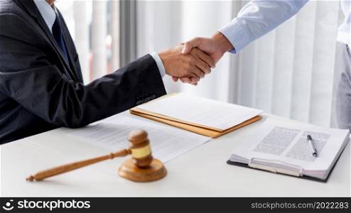 law concept The aider of solicitor who wears white shirt and the businessman shaking their hands firmly for having done their job well.
