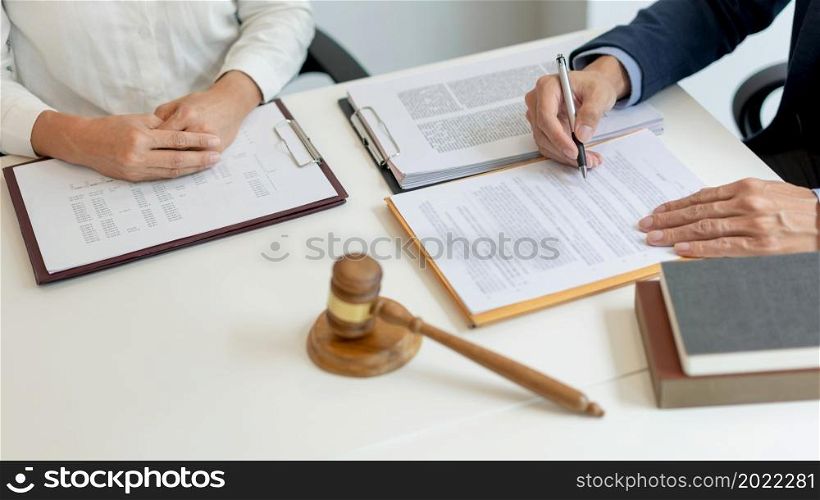 law concept The legal practitioner reading an official document that his advisee, the man in white long sleeved shirt hand to him and writing the signature on it.