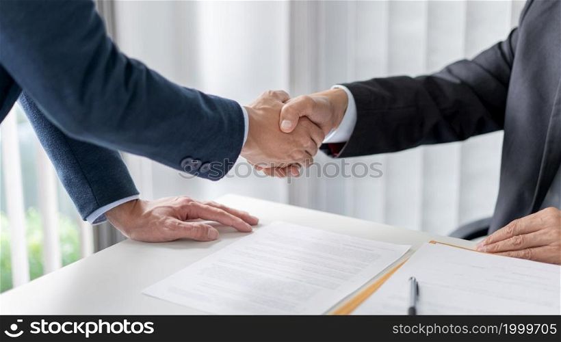 law concept The solicitor and the businessman shaking their hands firmly for having done their job well.