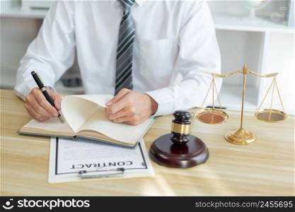 Law consultancy concept A male prosecutor reviewing his sentences of contract on his own notebook before writing them down on the contract paper