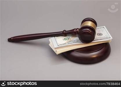 Law gavel on a stack of dollars isolated on gray background