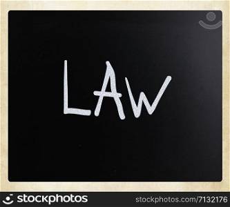 ""Law" handwritten with white chalk on a blackboard"