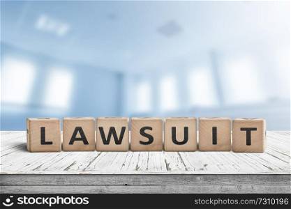 Lawsuit sign on a wooden table in a blurry bright blue room