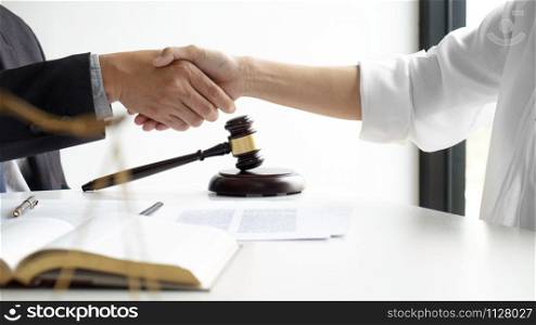 Lawyer and client handshake with contract agreement signing in law firm.