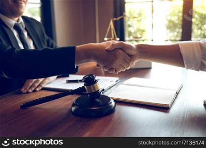 Lawyer is currently shaking hands with the client about the success in resolving the case.