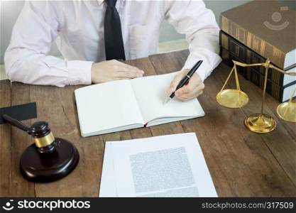 lawyer judge reading documents at desk in courtroom working on wooden desk background. gavel golden Weight. and soundblock of justice