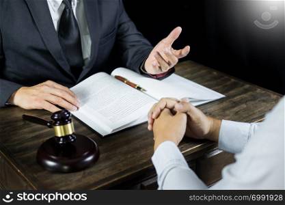 Lawyer or judge consult meeting with client at a law firm about legal legislation in courtroom with Judge gavel and Gold brass balance scale