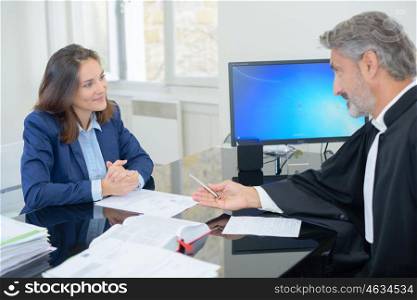 Lawyer passing pen to client to sign document