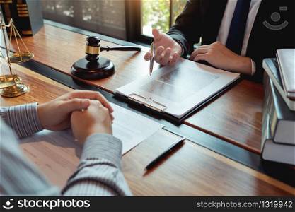 Lawyer working with client discussing contract papers with brass scale about legal legislation in courtroom, consulting to help their customer