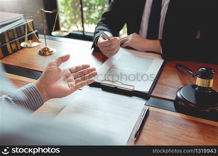 Lawyer working with client discussing contract papers with brass scale about legal legislation in courtroom, consulting to help their customer