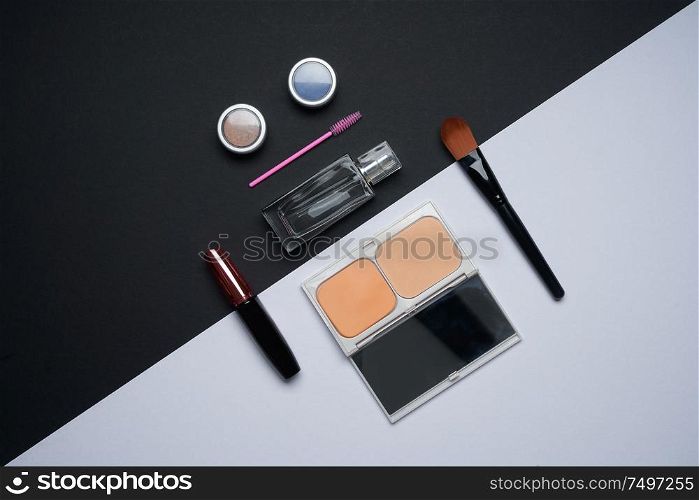 Lay composition beauty cosmetic accessories on white and black background