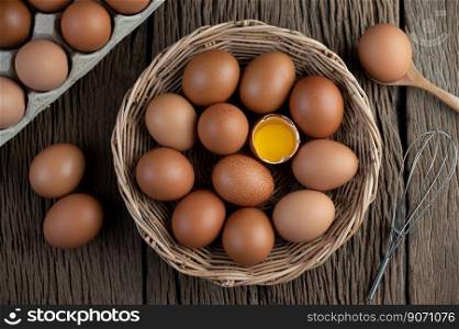 Lay eggs in a wooden basket on a wooden floor. Top view.